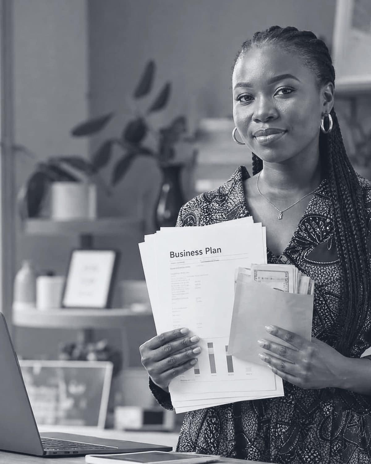 A founder in her workspace holding her business plan.