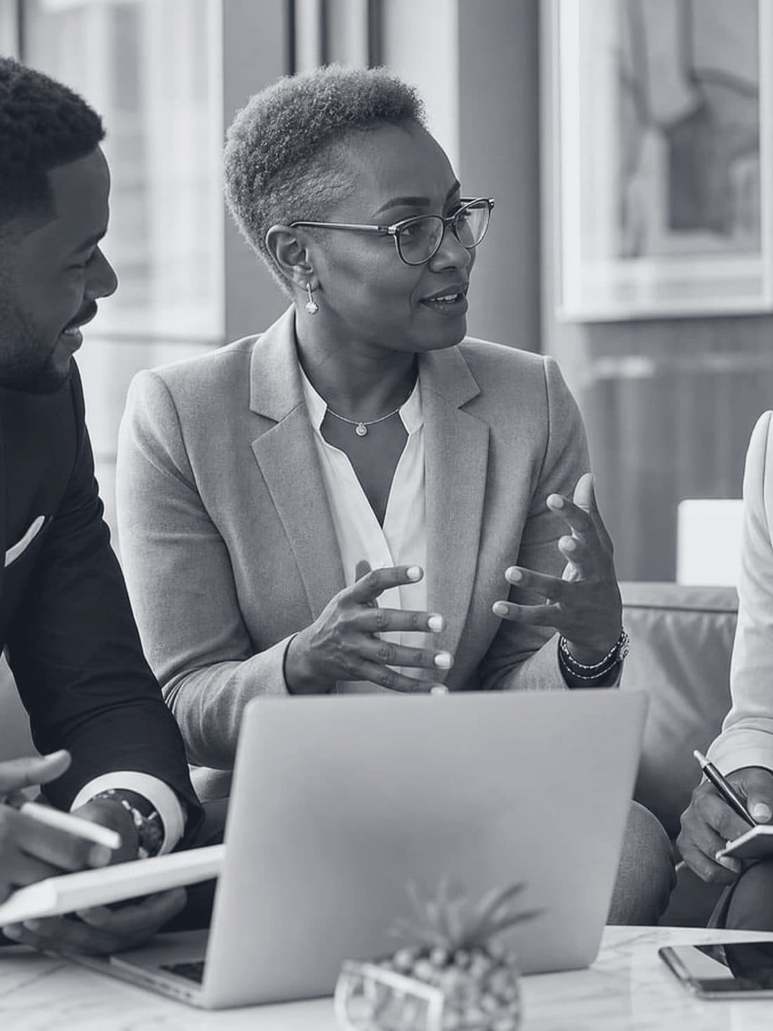 A senior mentor in conversation with two founders over a laptop.
